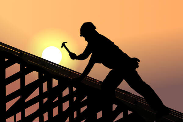 Zdjęcie przedstawia dekarza w trakcie prac na dachu